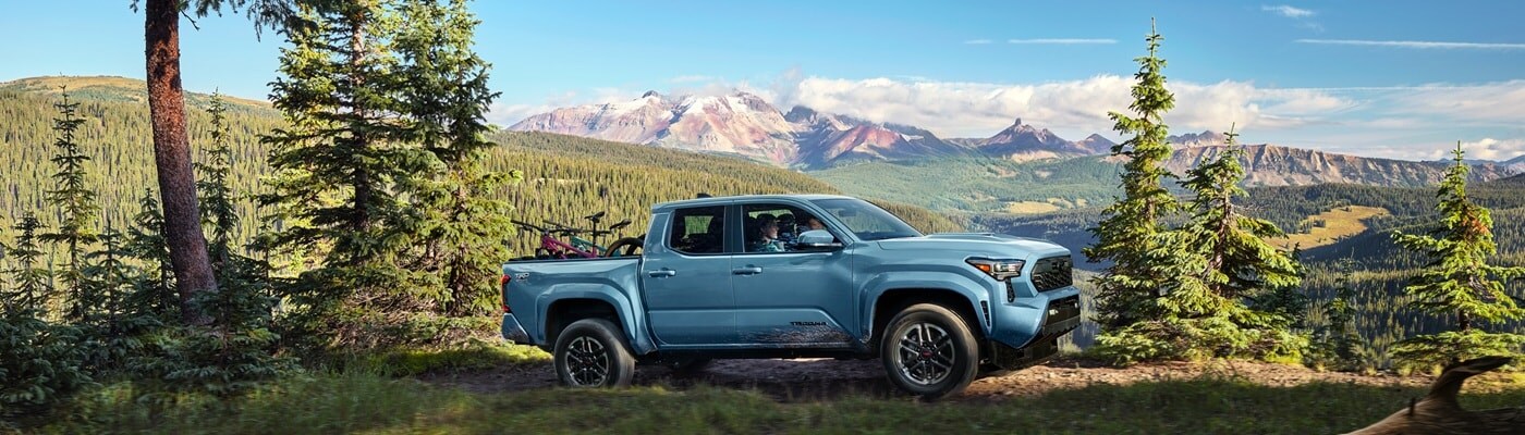 Light Blue Toyota Tacoma driving up a mountain road