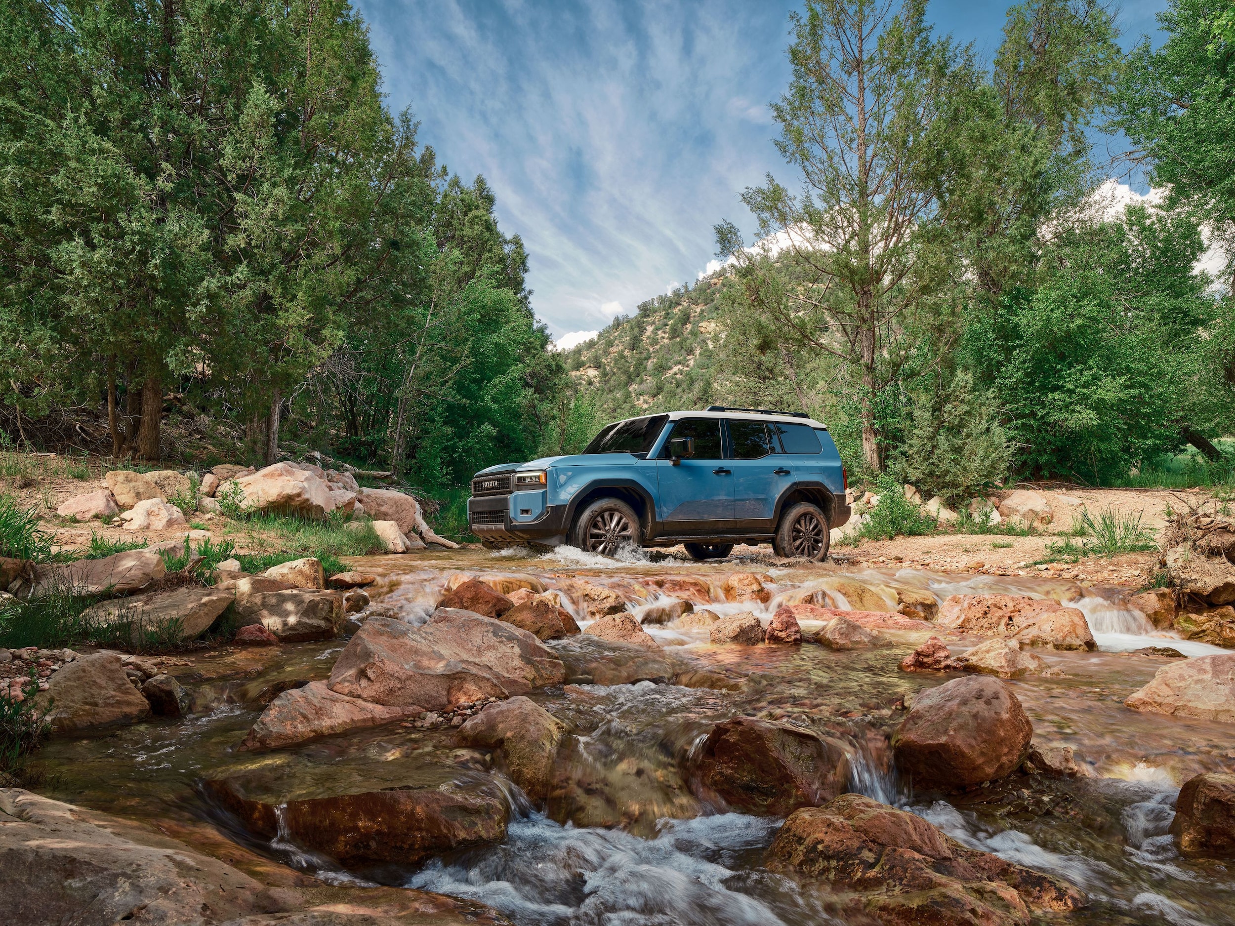 Toyota Land Cruiser driving in rocky stream