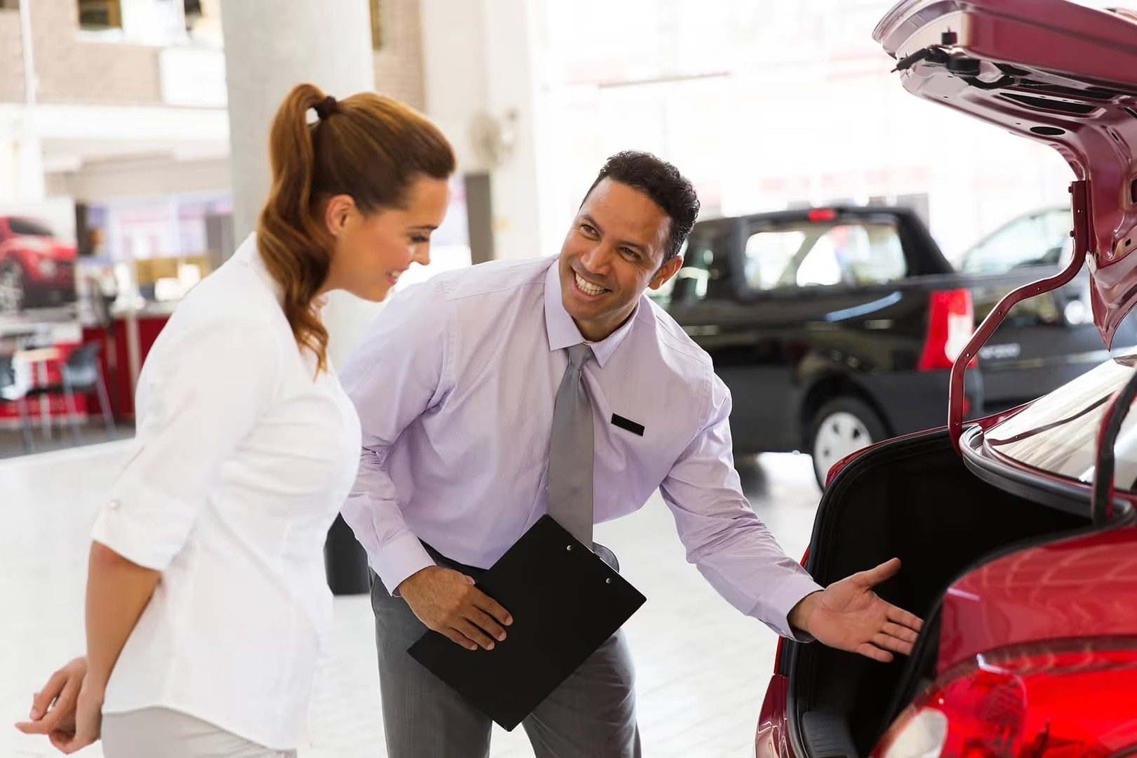 car salesman talking to customer at dealership