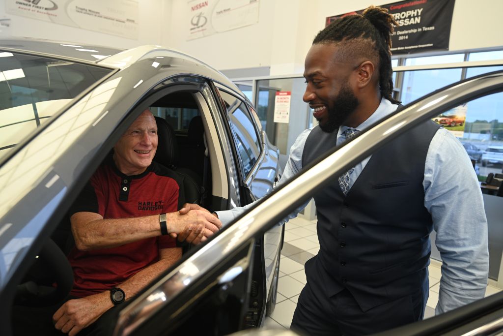 A Trophy Nissan employee shaking a customer's hand