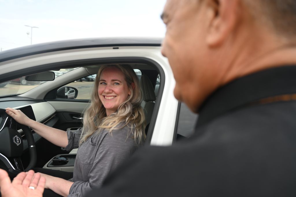 A Trophy Nissan employee talking to a customer in a vehicle