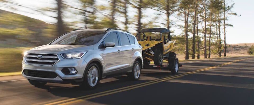 Ford Escape A Ford Escape towing an ATV down a road