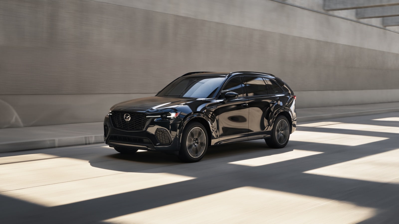 A black mazda cx-70 driving on the road.
