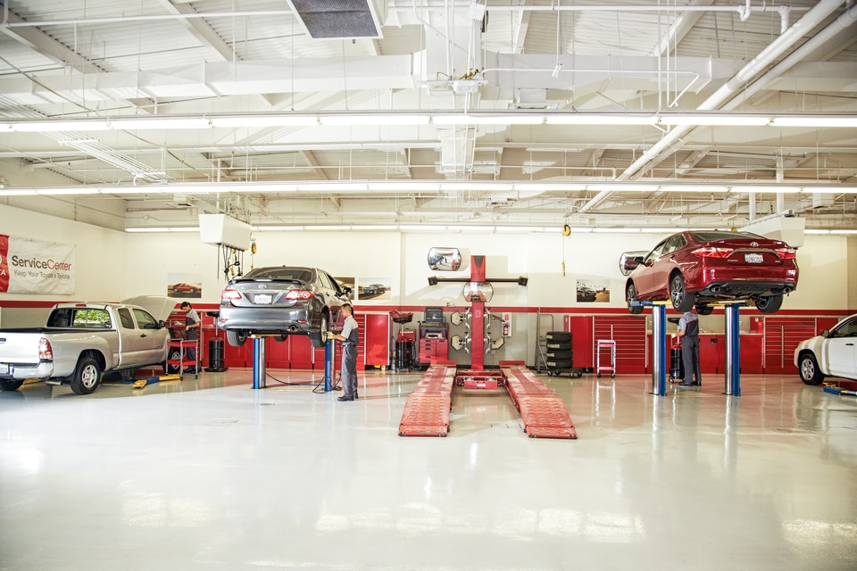 Toyota Collision Center Technician buffing out vehicle body panel.