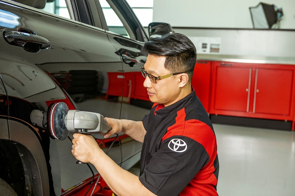 Car parts being painted by service technician
