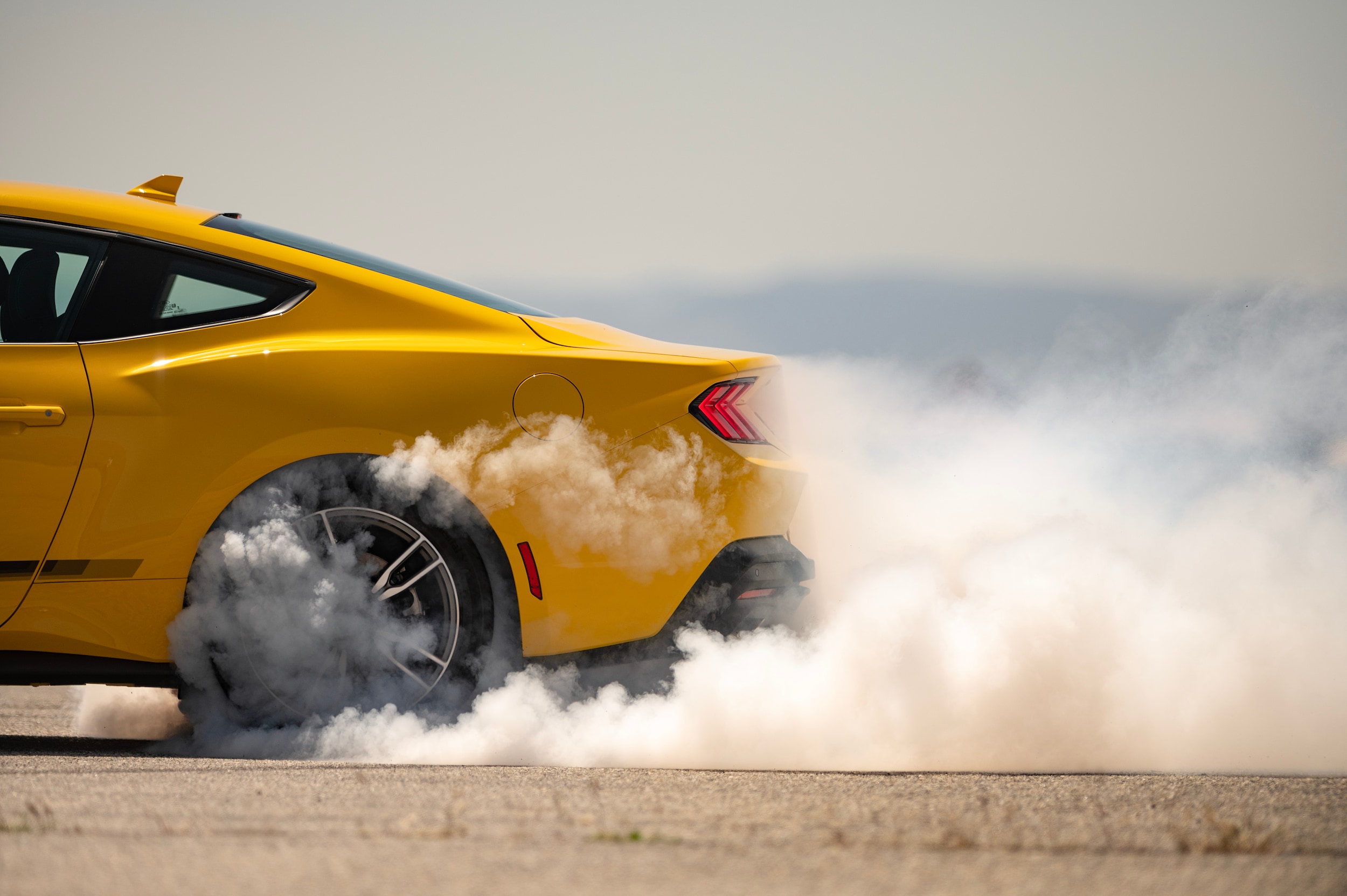 Ford Mustang kicking up dust on racetrack