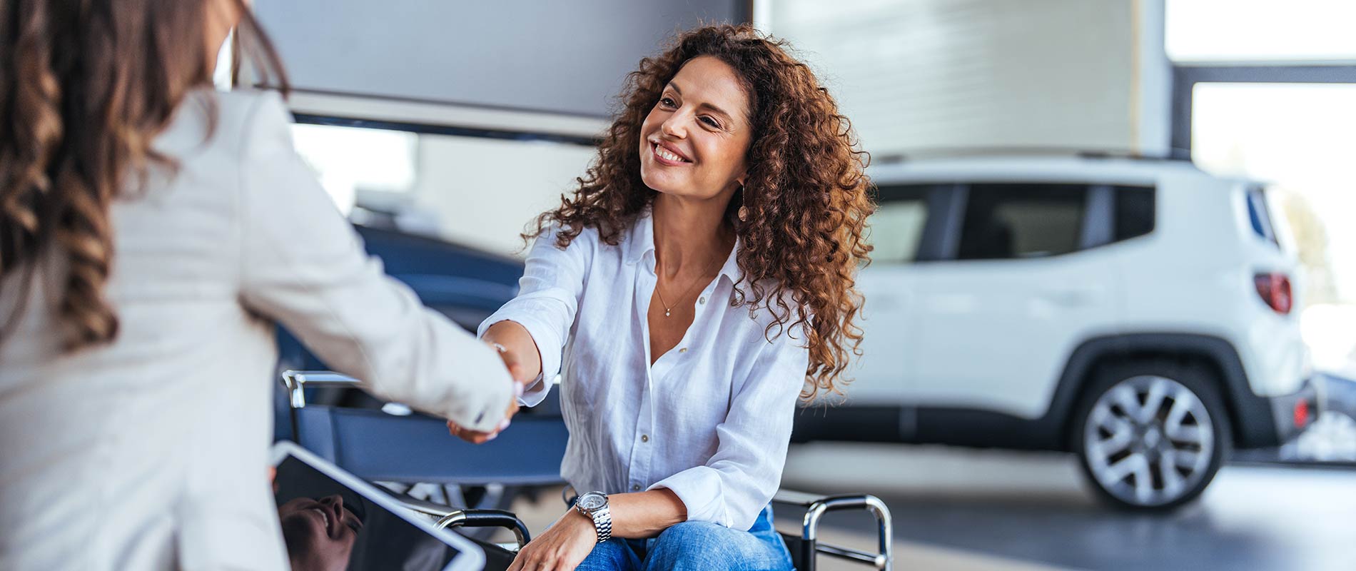 Smiling woman shaking hands with a sales representative