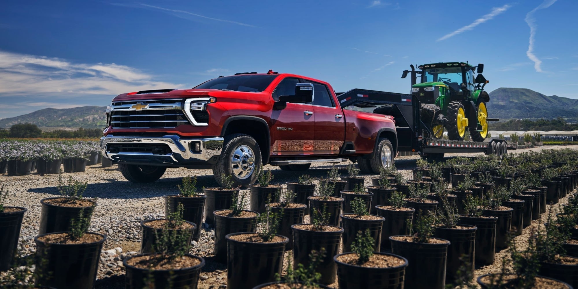 Red Silverado HD towing a tractor