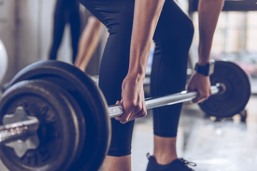 Woman lifting up a weight at a gym