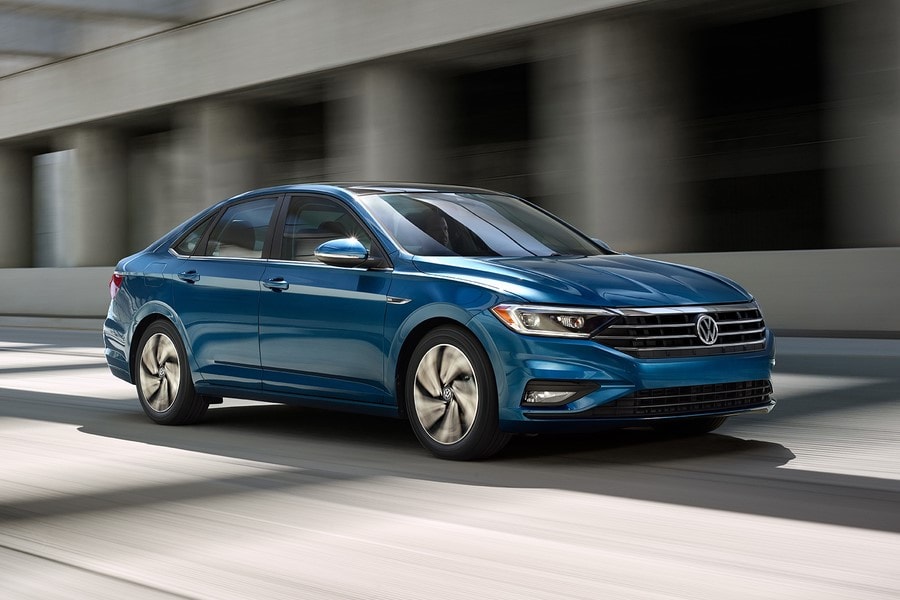 blue Volkswagen jetta driving through an underpass