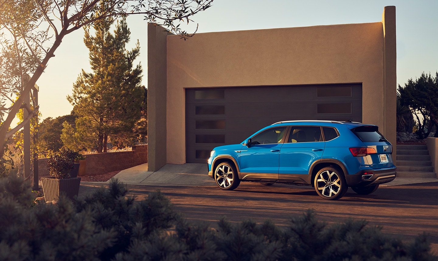 blue Volkswagen SUV parked in front of an adobe style home