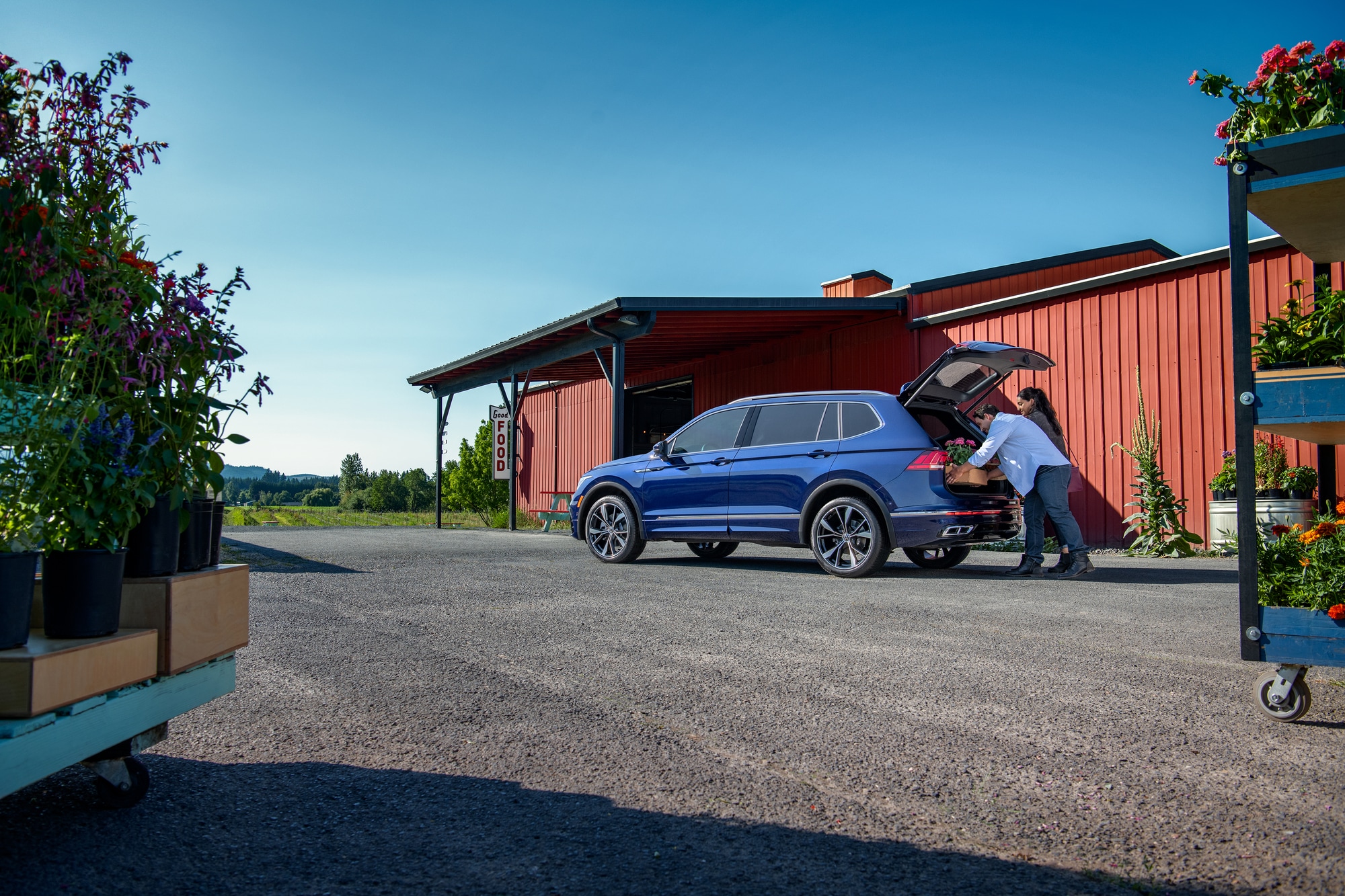 Couple packing the trunk of a new Volkswagen Tiguan with flowers