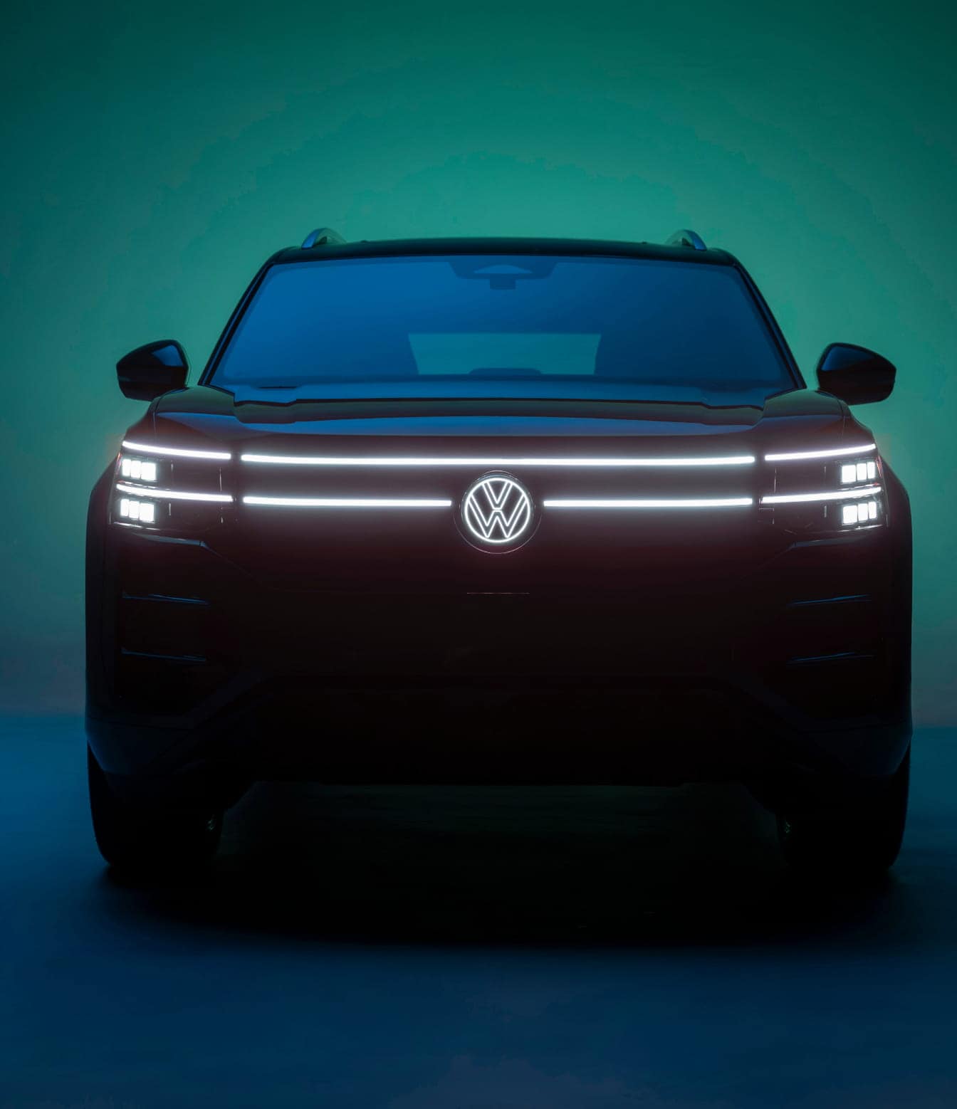 Front view of a 2027 Volkswagen Atlas with illuminated headlights and grille.