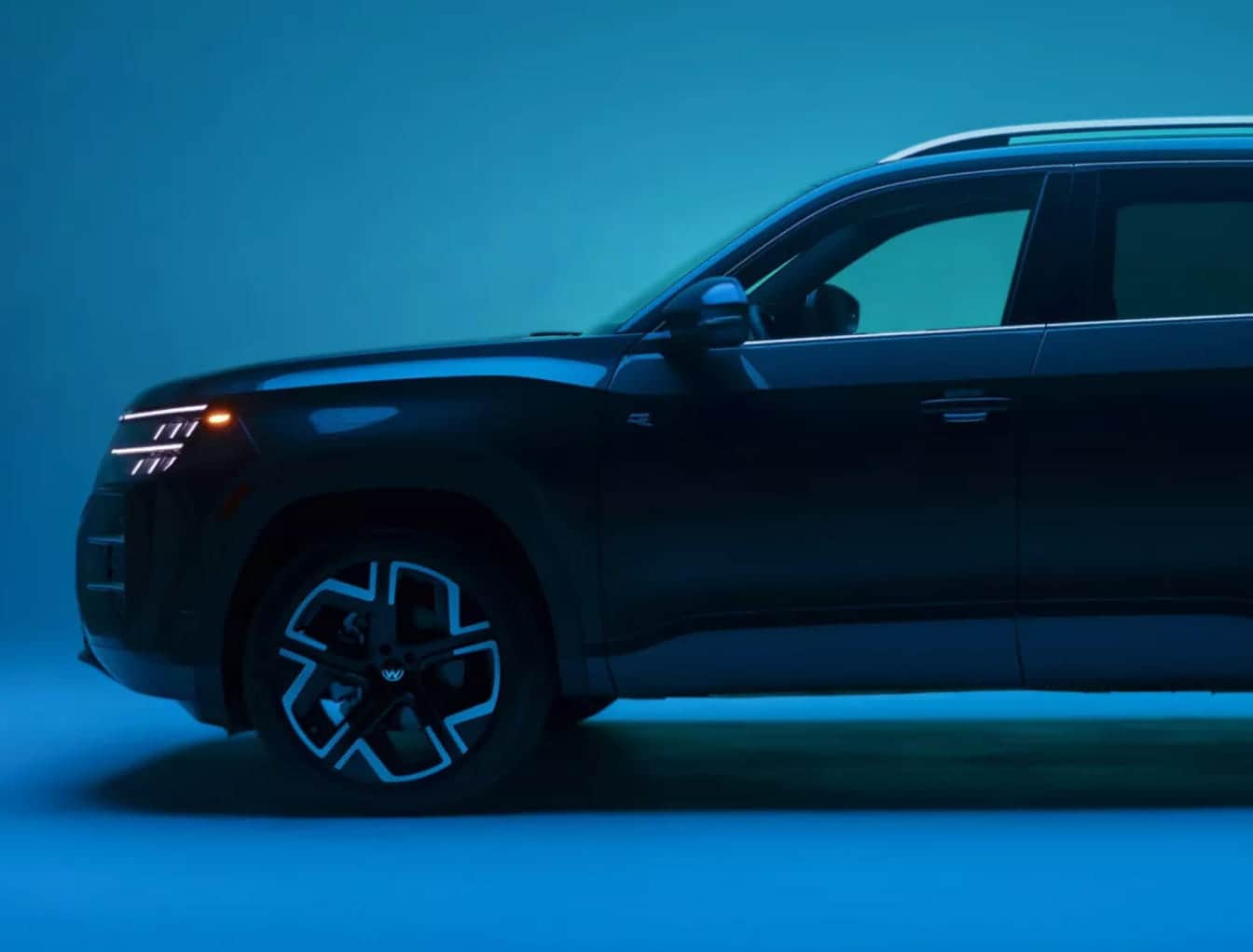 2027 Volkswagen Atlas shown from the side under blue lighting.