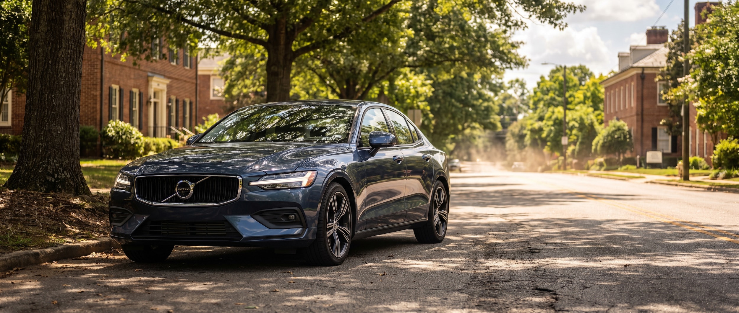 2025 Volvo S60 T8 plug-in hybrid sedan on a shaded Greenville SC street in summer