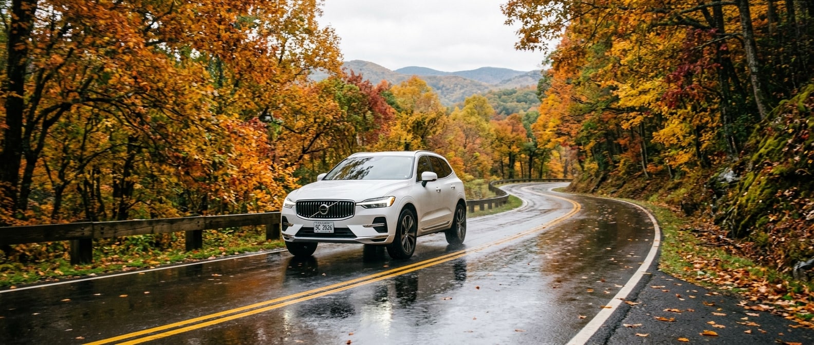 2026 Volvo XC60 on a wet leaf-covered mountain road in Upstate South Carolina during fall foliage season