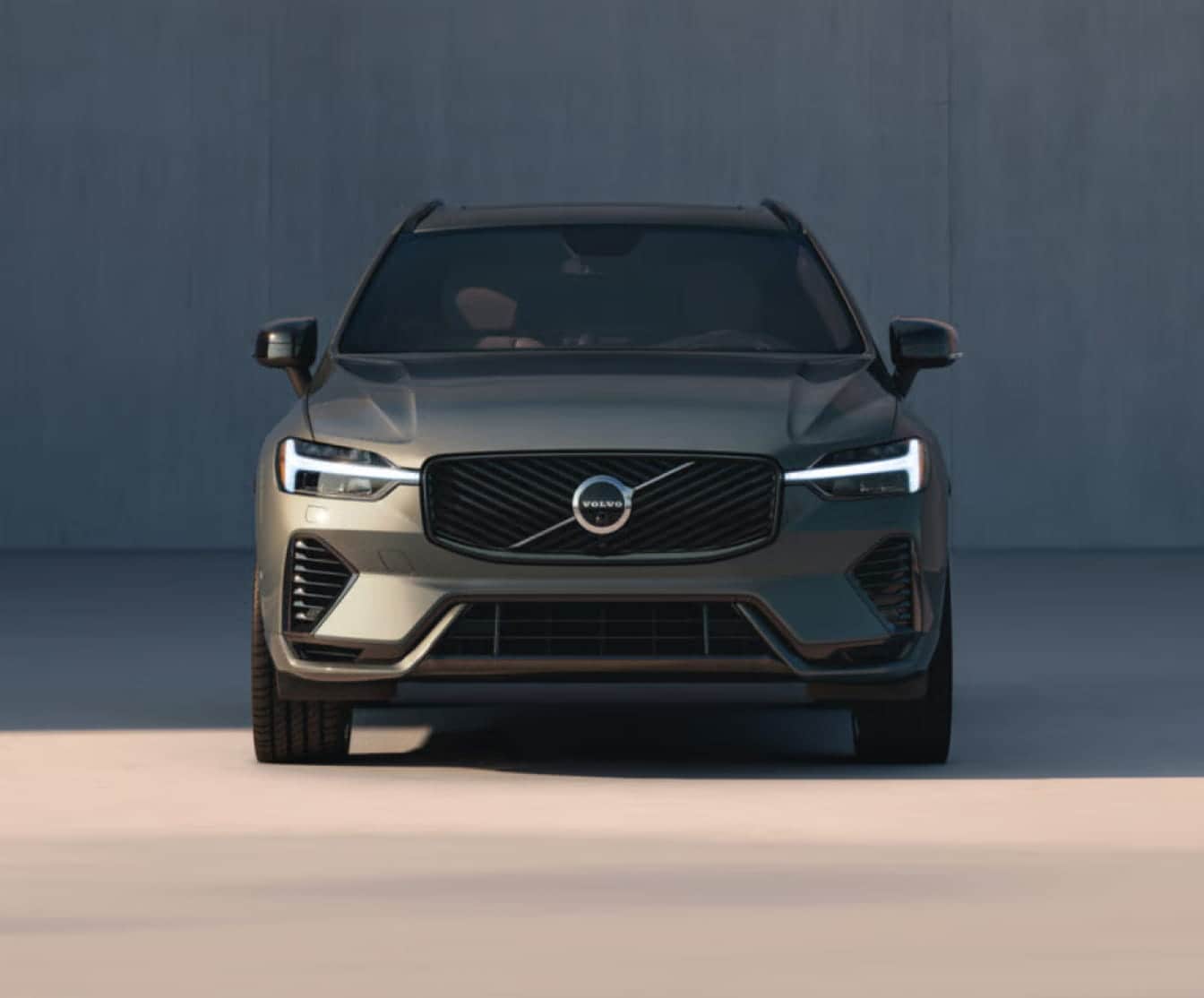 Front view of a Volvo XC60 SUV with signature LED headlights illuminated.