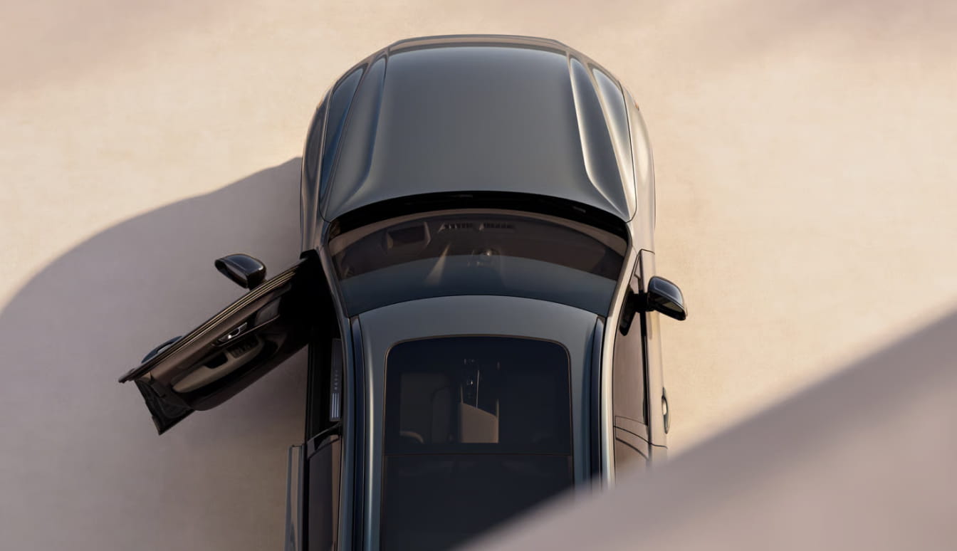 Top-down view of a Volvo XC60 highlighting the panoramic roof and open driver door.