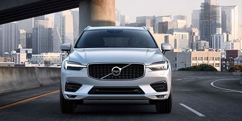 Volvo of New Bern is a Car Dealership in New Bern near Hubert NC | Silver 2020 Volvo XC60 driving on city road