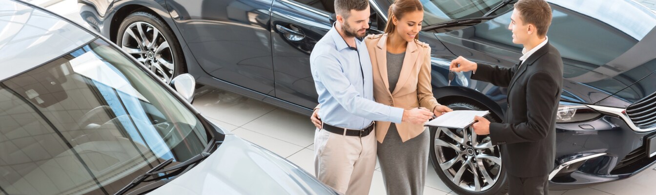 Volvo Sales Associate handing keys over to new buyers