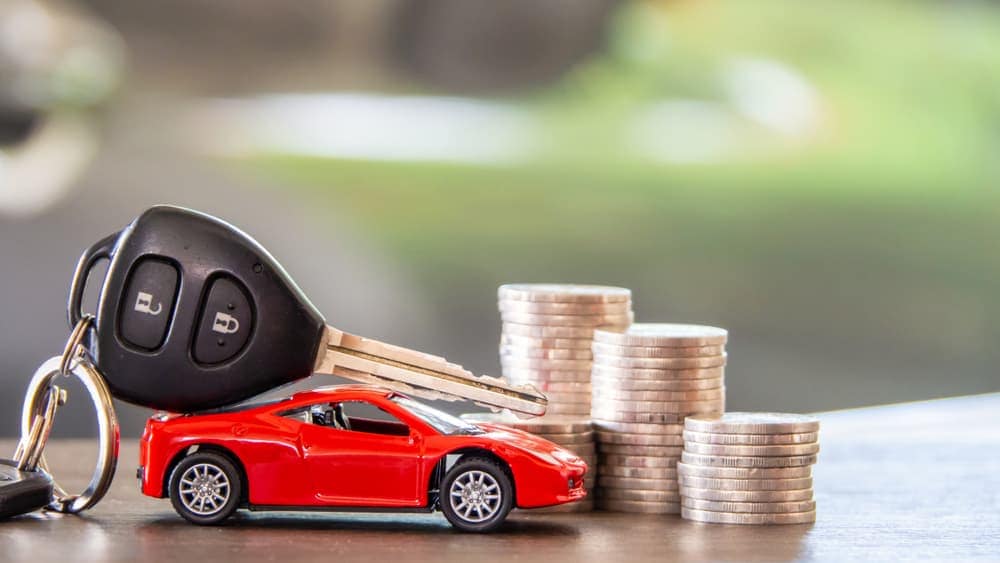 New car keys and a toy car on a desk.jpg