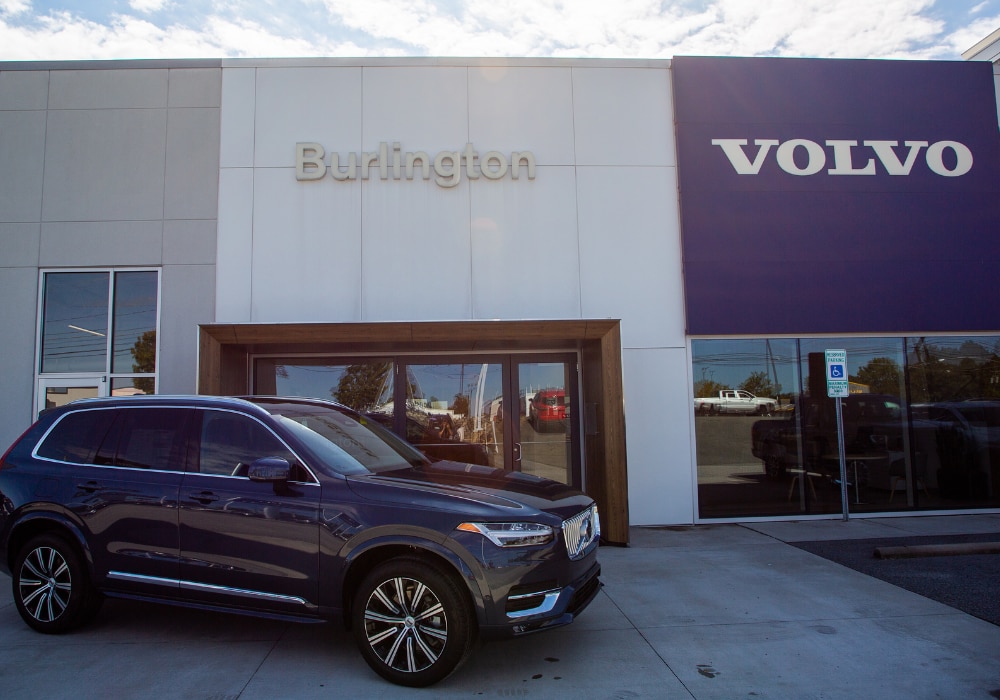 Black Volvo SUV parked outside the Flow Volvo of Burlington dealership storefront