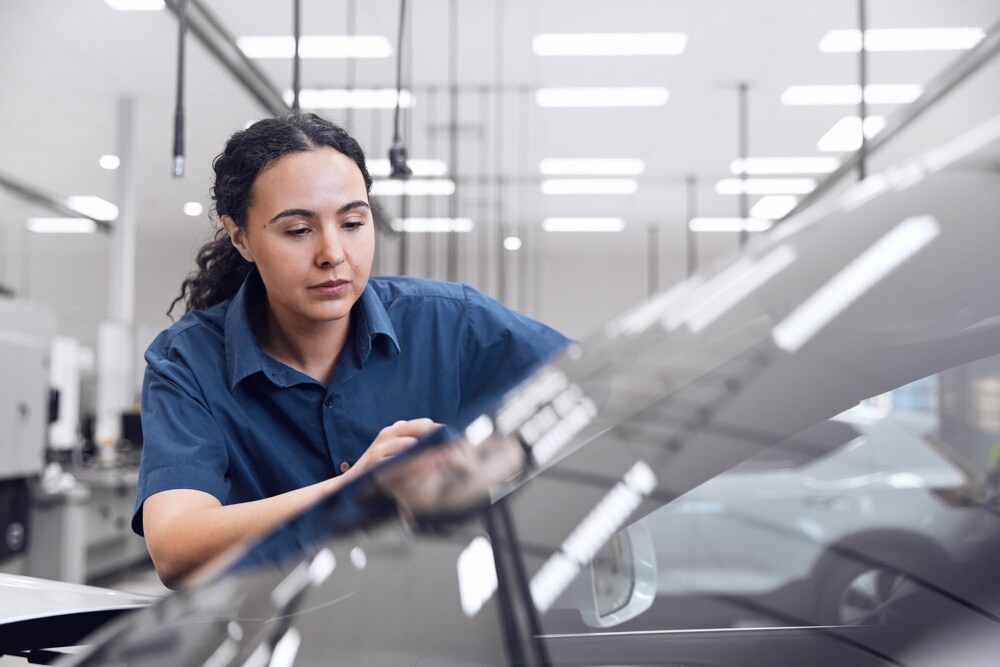 Volvo technician polishing a windshield