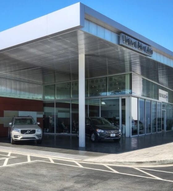Wide exterior view of the Volvo Palo Alto showroom with a silver and black Volvo SUV parked in front.