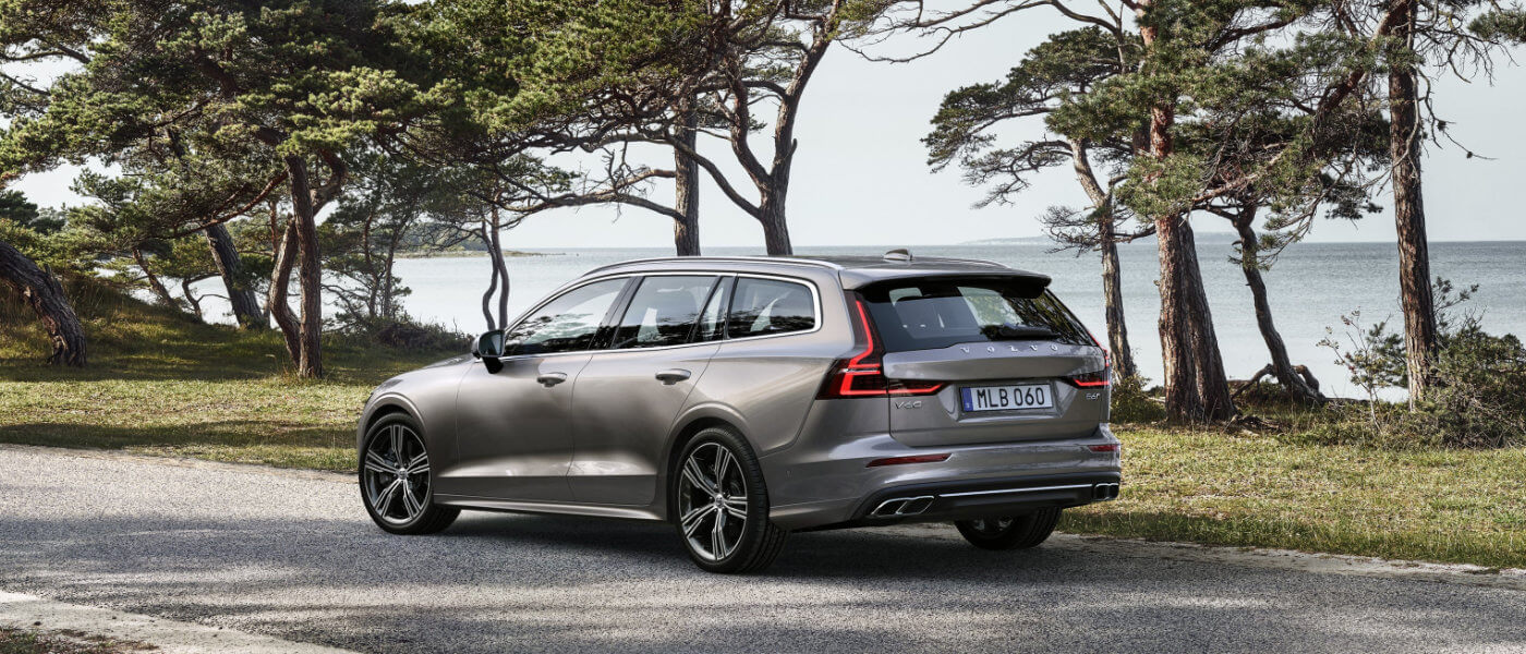2022 Volvo V60 driving in front of some trees