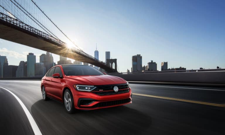 2019 Red VW Jetta GLI Driving on a Bridge past a Whiskey