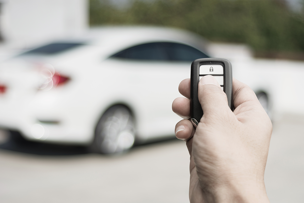 A driver unlocking their vehicle with their key fob