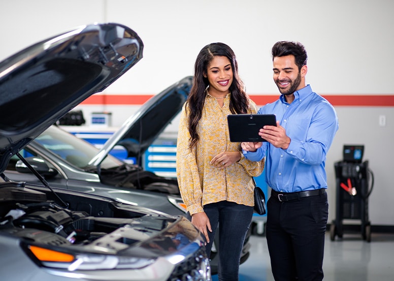 What is included in a Multi-Point Inspection? | West Broad Hyundai in Richmond | Hyundai Service Advisor Showing Results of Multi-Point Inspection to Customer While Standing Next to Hyundai Vehicle