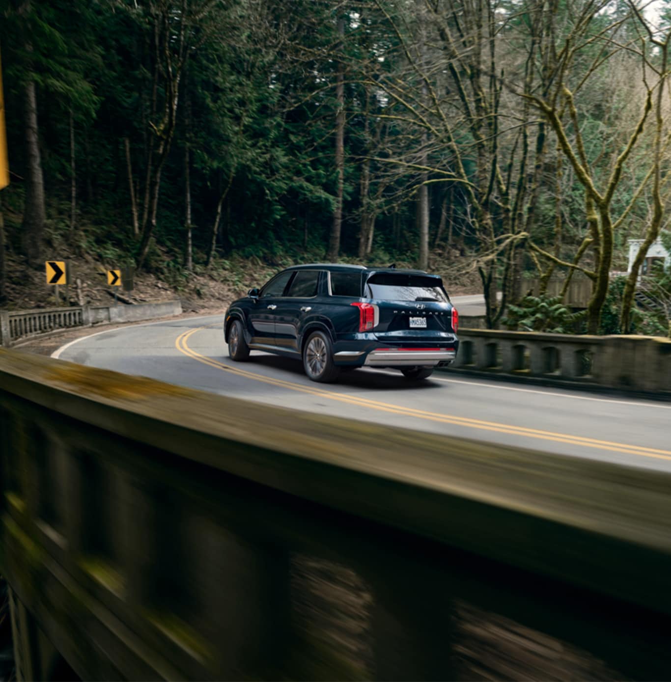 All-New 2023 Hyundai Palisade at West Broad Hyundai | Rear view of a navy blue Hyundai Palisade driving down the road 
