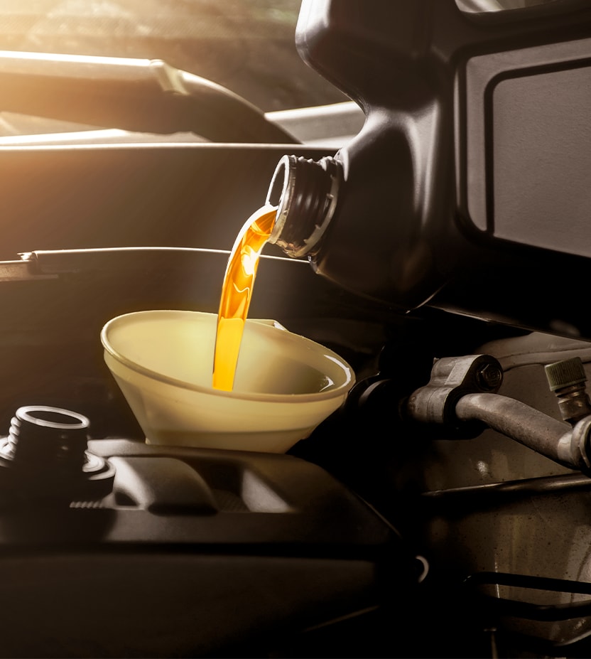 Extend the Life of Your Vehicle at West Broad Kia in Henrico, VA | Yellow synthetic oil poured into engine from black oil bottle 