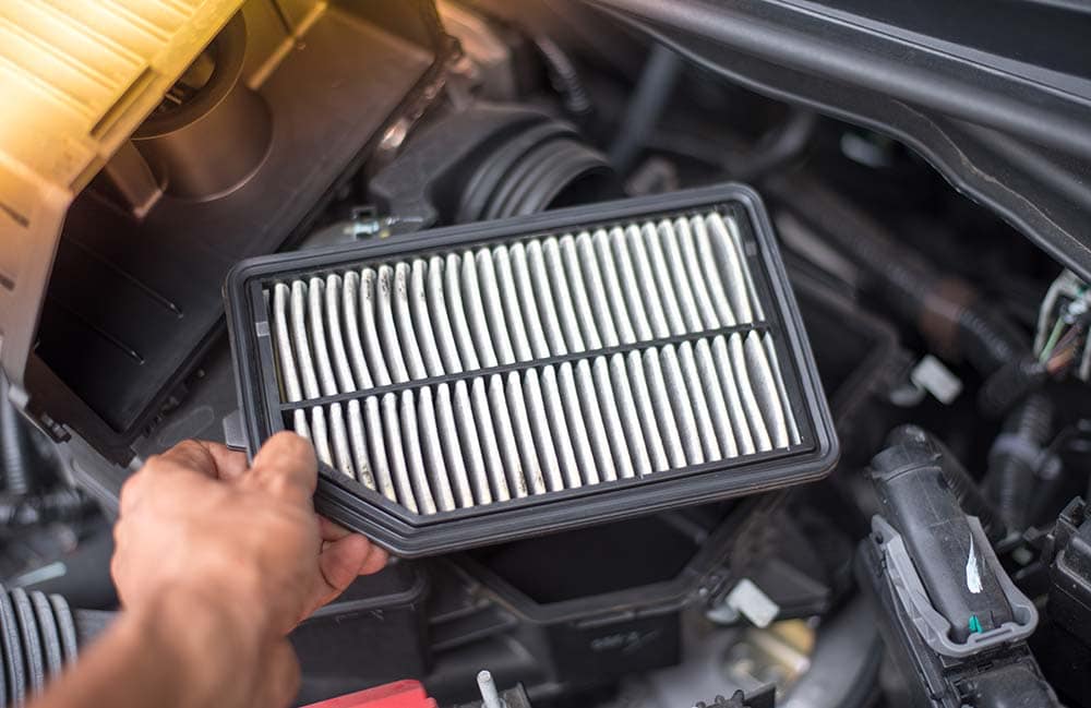 Cabin air filter replacement at West Broad Kia | Kia service technician replacing old air filter