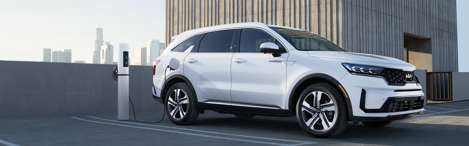 The All-New 2022 Kia Sorento Plug-In Hybrid at West Broad Kia in Richmond | White 2022 Kia Sorento Plug-In Hybrid Charging While Parked on Top Floor of Parking Garage