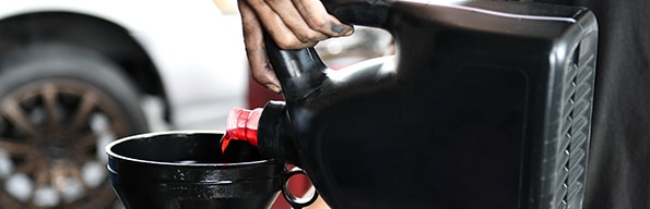 Difference between synthetic oil & conventional oil at West Broad Kia | Pouring Oil into funnel