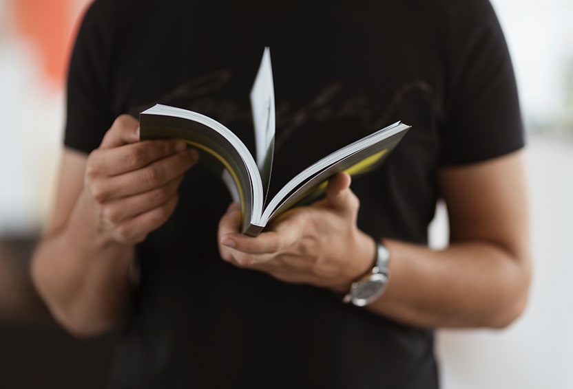 Extend the Life of Your Vehicle at West Broad Kia in Henrico, VA |  Man in black shirt is reading thorugh his owners manual 