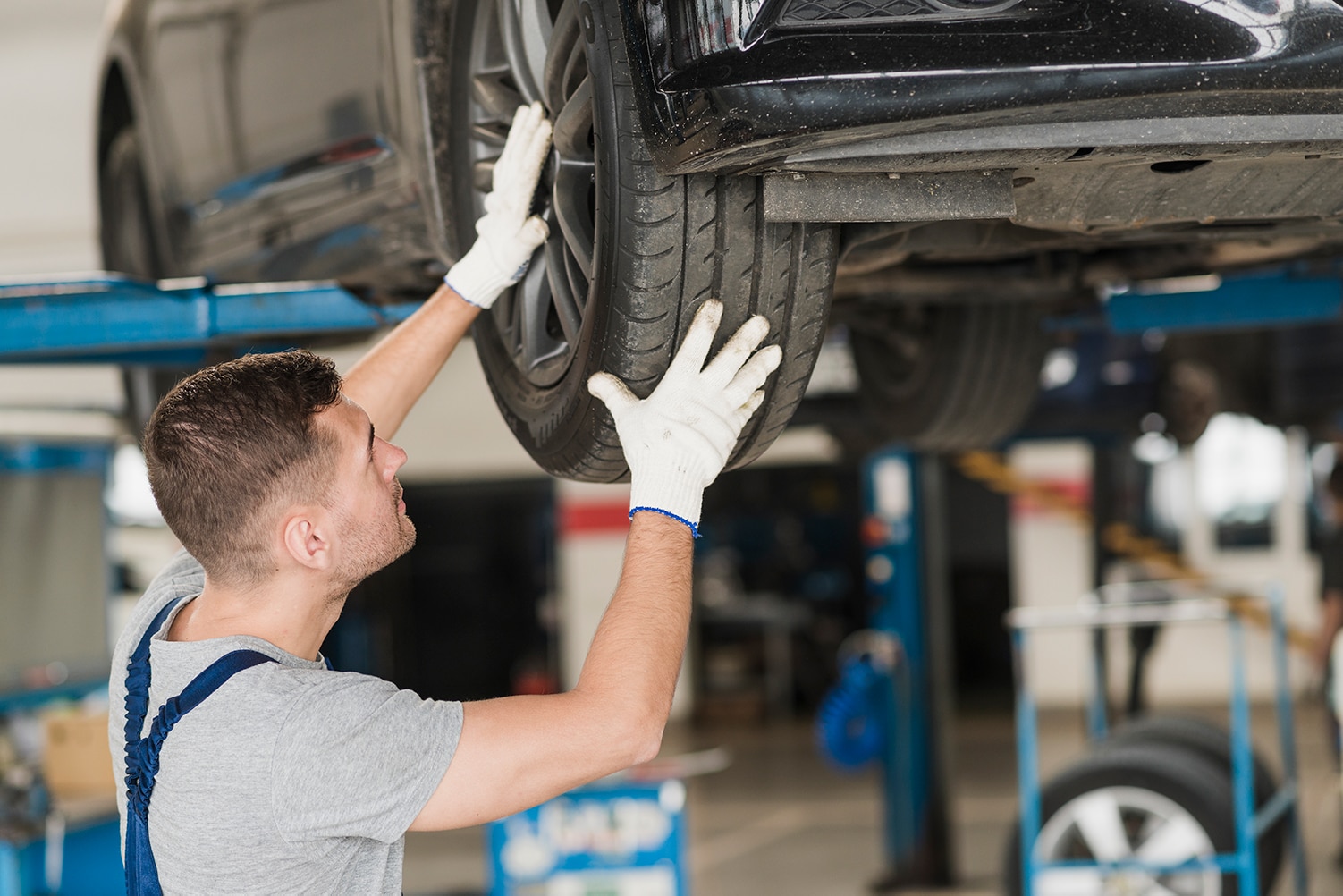 West Broad Kia is a Kia Dealership in Richmond near Ashland, VA | Kia mechanic insoecting tires