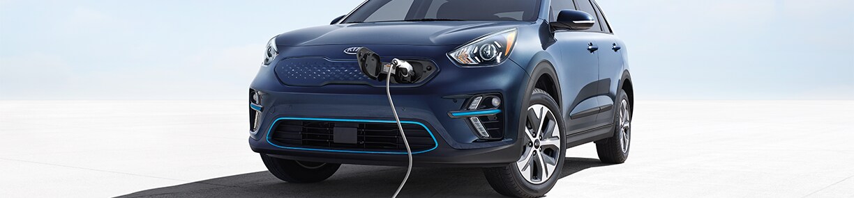 How to prepare your home for your new Electric Vehicle at West Broad Kia in Henrico, VA | Blue 2022 Kia Niro charging with a charing cable connected to the front of the car