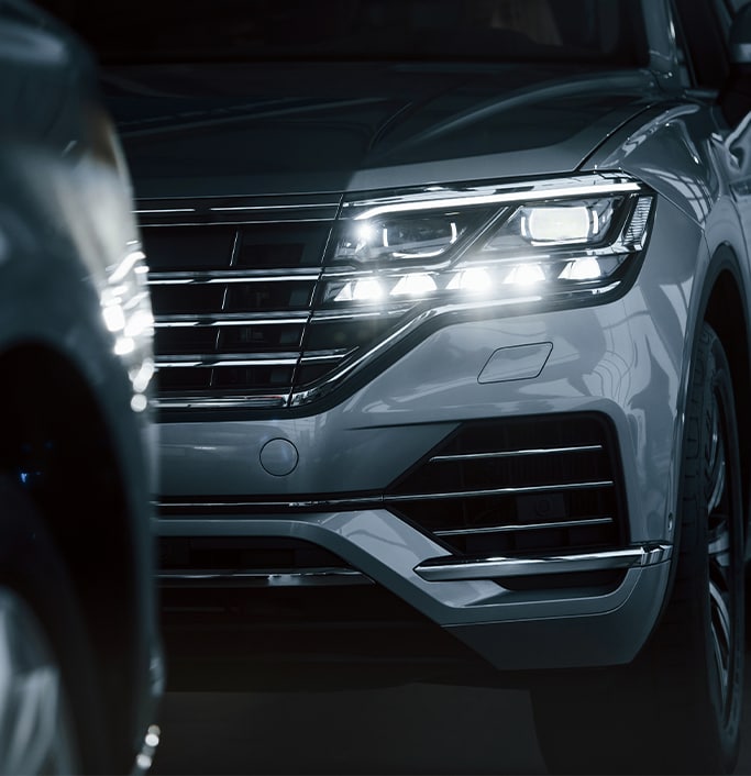 When to Trade In Your Car | West Broad Kia in Henrico, VA | Parked Silver SUV with its headlights on