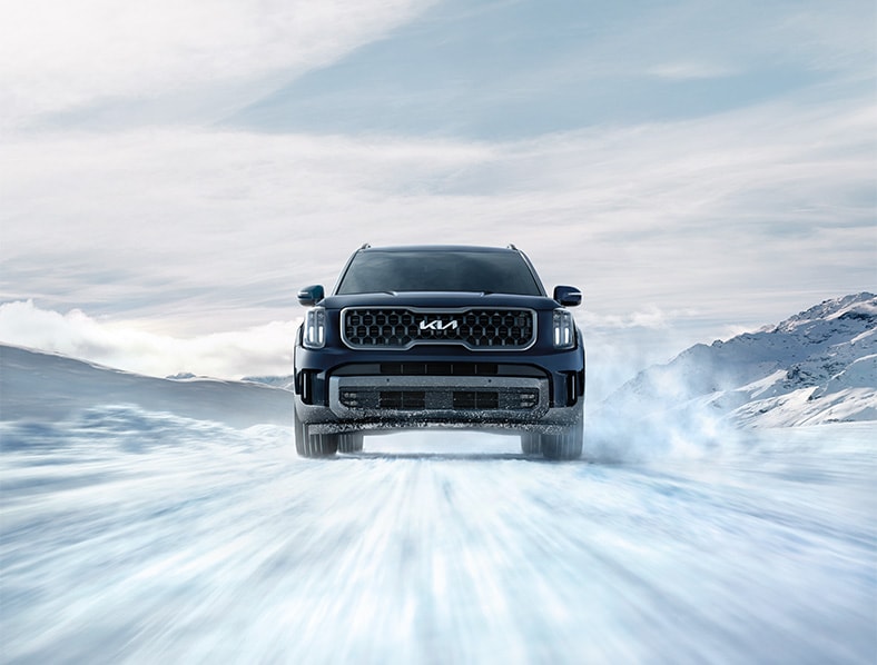The Cold Facts of Winter Tires | West Broad Kia in Henrico, VA | Front profile of a 2024 Kia Telluride driving on a road filled with snow 