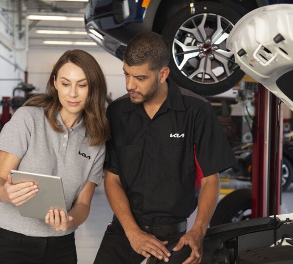 Basic Car Maintenance and Servicing Checklist | West Broad Kia | Two Kia Service Technicians Looking at a Tablet