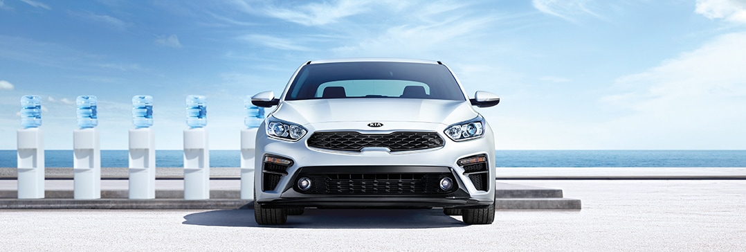 Compare the 2021 Kia Forte vs. the 2022 Toyota Corolla at West Broad Kia | Forte parked at beach