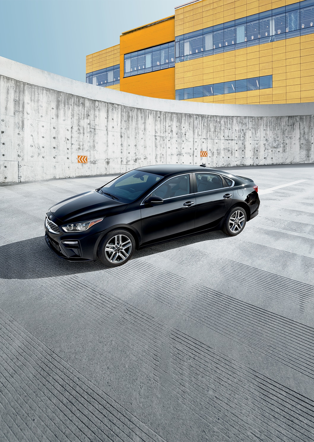 2023 Kia Forte at West Broad Kia in Henrico, VA | Side profile of a black 2023 Kia Forte driving down a parking lot  