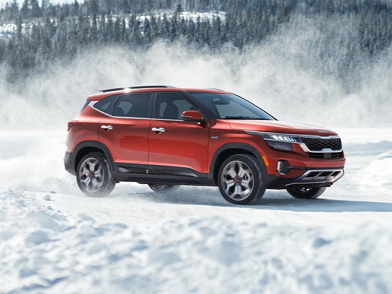 what different tire options are available at West Broad Kia in Richmond | Orange 2022 Kia Seltos Driving Through Field Covered in a Layer of Snow