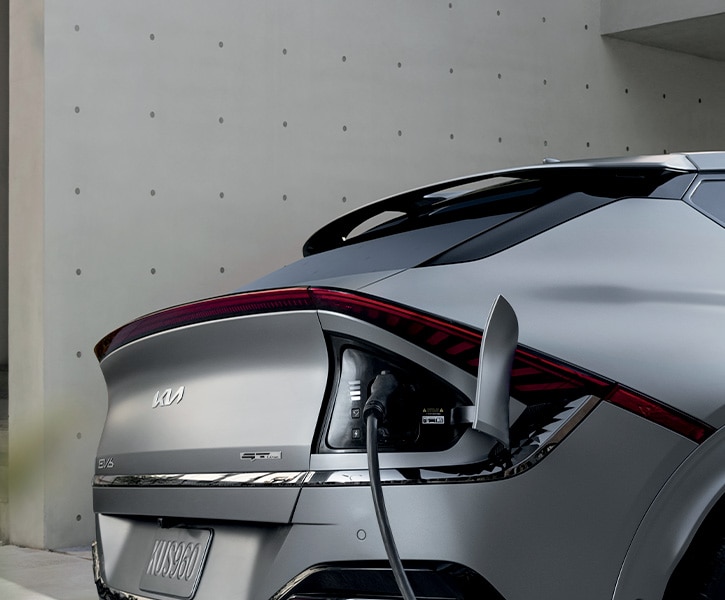 The 2022 Kia EV6 is Coming Soon to West Broad Kia in Richmond | Close-Up View of Charging Port in Use on Silver 2022 Kia EV6