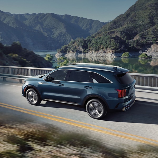 The All-New 2022 Kia Sorento Plug-In Hybrid at West Broad Kia in Richmond | Blue 2022 Kia Sorento Plug-In Hybrid Driving on Bridge Over Body of Water