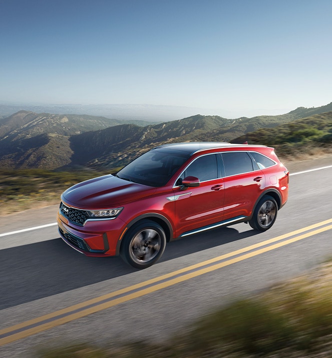 The All-New 2022 Kia Sorento Plug-In Hybrid at West Broad Kia in Richmond | Red 2022 Kia Sorento Plug-In Hybrid Driving on Mountainside Road