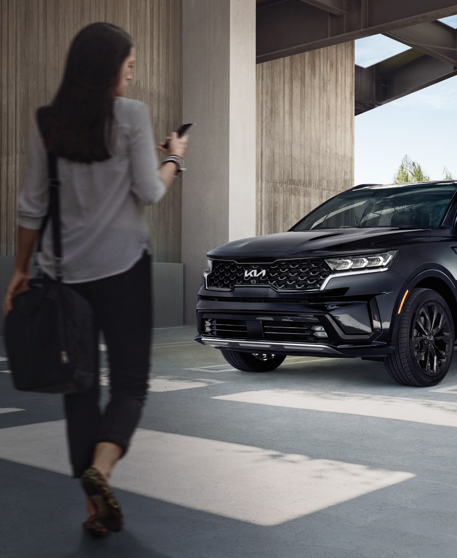 High Cost of Replacing a Car Key | West Broad Kia | Woman Looking at her Phone Walking Towards her 2022 Kia Sorento SX Prestige